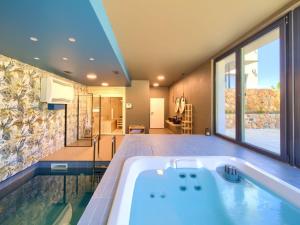 a large bathroom with a tub and a large window at Villa Miryam by Interhome in Vrh