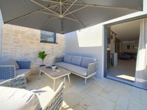 a patio with a couch and a table and an umbrella at Villa Miryam by Interhome in Vrh