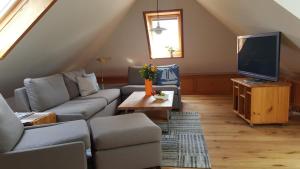 a living room with a couch and a tv at Herich in Nieblum +15 photos