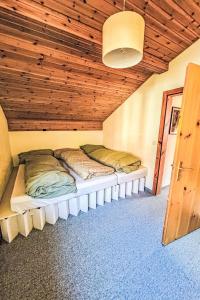 two beds in a room with a wooden ceiling at Apartment Casa Foppa by Interhome in Somvix +17 photos