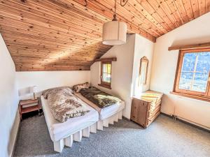 a bedroom with two beds and a wooden ceiling at Apartment Casa Foppa by Interhome in Somvix