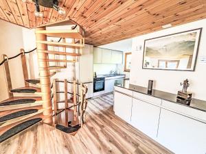 a spiral staircase in a kitchen with white cabinets at Apartment Casa Foppa by Interhome in Somvix
