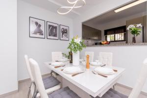 a white dining room with a white table and chairs at Cristian Sur Luxury 2 Bedroom Apartment in Los Cristianos +20 photos