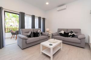 a living room with two couches and a table at Cristian Sur Luxury 2 Bedroom Apartment in Los Cristianos