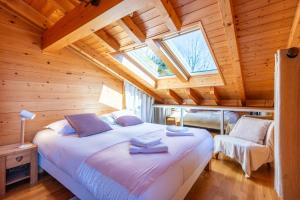 sypialnia z dużym łóżkiem i oknem dachowym w obiekcie Slow Chalet Tekoa 8 pers - 5 min from the slopes w mieście Manigod