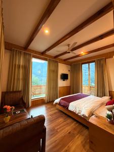 a bedroom with a bed and a couch and windows at Bens Villa in Haripūr