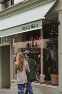 a man and woman walking in front of a store window at Hôtel Suzie Blue in Paris