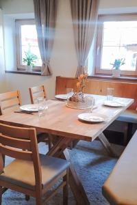 una mesa de madera con sillas, platos y vasos en Apartment Schiestl by Interhome, en Uderns 25 fotos más