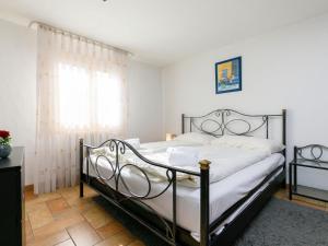 Un dormitorio con una cama con sábanas blancas y una ventana. en Apartment Apt-31 by Interhome, en Silvaplana