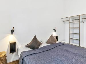 a white bedroom with a large bed with pillows at Holiday Home Sonnenpfad by Interhome in Lembruch