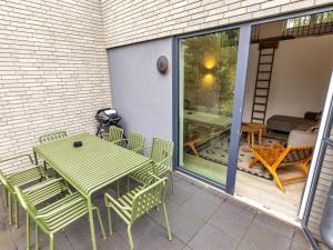 a green table and chairs on a patio at Holiday Home Sonnenpfad by Interhome in Lembruch
