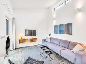 a living room with a couch and a tv at Holiday Home Windlicht by Interhome in Lembruch