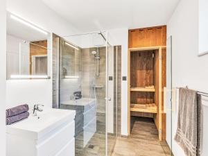 a white bathroom with a sink and a shower at Holiday Home Windlicht by Interhome in Lembruch