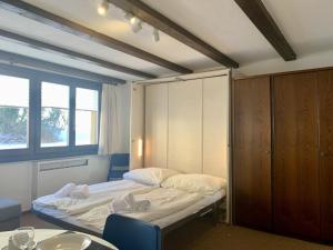 a small room with a bed and a table at Apartment Apt- 33-1 by Interhome in Surlej