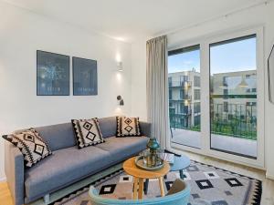 a living room with a couch and a large window at Apartment Imort by Interhome in Lembruch