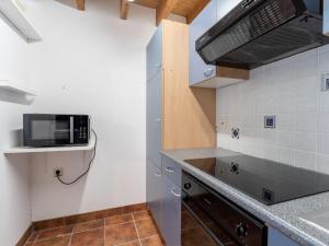 een keuken met een spoelbak en een magnetron bij Holiday Home Polderzicht with parking by Interhome in Mispelburg