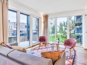 a living room with a couch and chairs and large windows at Apartment Seeidyll by Interhome in Lembruch