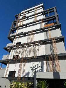 ein hohes Gebäude mit einem Schild an der Seite in der Unterkunft Melhores Flats - Seu desejo, pé na areia in Tambaú + 35 Fotos