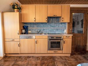 a kitchen with wooden cabinets and a stainless steel oven at Holiday Home Bio-Landhaus Kesslerhof-6 by Interhome in Moosheim