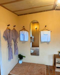 a room with a mirror and some shirts hanging on a wall at Hobbit noi in Ban Huai Khai