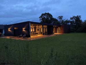 a small black house with a deck in a field at Holiday Home Emelina - 300m from the sea by Interhome in Rude