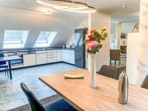 a kitchen with a table with a vase of flowers on it at Holiday Home Naturnah mit Pool und Sauna by Interhome in Waldau