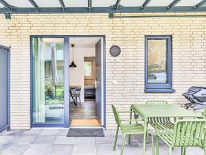 a patio with a table and chairs next to a brick wall at Apartment Seeruhe by Interhome in Lembruch