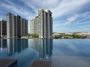 Ein großes Schwimmbecken mit hohen Gebäuden im Hintergrund in der Unterkunft Shelisa's Cozy Retreat at Southplace Subang in Subang Jaya