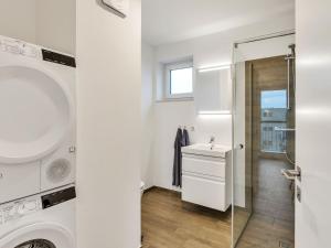 a bathroom with a sink and a washing machine at Apartment Seeflair by Interhome in Lembruch