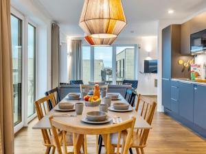 a dining room with a table with chairs and a kitchen at Apartment Seeflair by Interhome in Lembruch