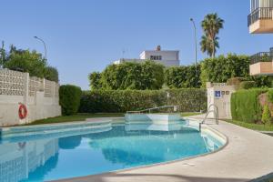 a swimming pool with blue water in a yard at Albaida 3G Nerja in Nerja