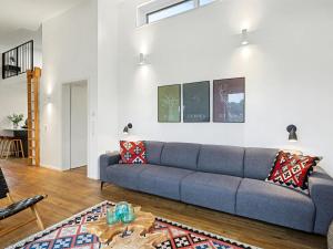 a living room with a blue couch and a table at Holiday Home Komfortzone by Interhome in Lembruch