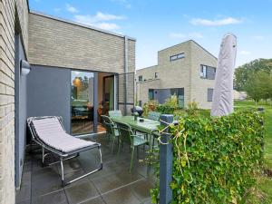 a patio with a table and chairs and a building at Holiday Home Komfortzone by Interhome in Lembruch