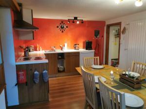 a kitchen and dining room with a table and a kitchen with red walls at Apartment Sandgrube 2- OG Süd by Interhome in Mörel