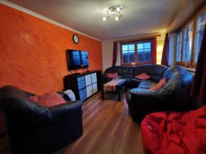 a living room with two leather couches and a tv at Apartment Sandgrube 2- OG Süd by Interhome in Mörel +43 photos