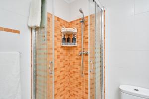 a bathroom with a shower with orange tiles on the wall at Albaida 3G Nerja in Nerja +18 photos