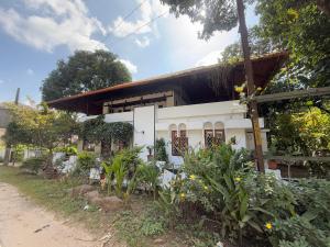 a white house with a black roof and some plants at Urban Minz in Mūvattupula