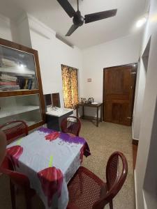 a dining room with a table with chairs and a ceiling fan at Urban Minz in Mūvattupula