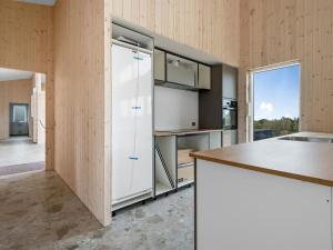 a kitchen with white cabinets and a large window at Holiday Home Gillis - 1km from the sea by Interhome in Tvedhuse