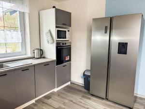 a kitchen with a stainless steel refrigerator and a microwave at Holiday Home Hostyn Hills by Interhome in Bystřice pod Hostýnem +19 photos