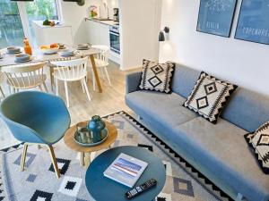 a living room with a blue couch and a table at Apartment Penthouse Seevibes by Interhome in Lembruch