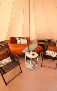 ein Zelt mit einem Bett, zwei Stühlen und einem Tisch in der Unterkunft Unique Secluded Glamping Tent with Spectacular Canyon and River Views in Moab, Utah in Allen Memorial Hospital Heliport