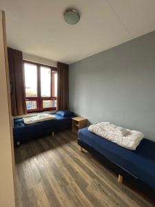 a room with two beds and a window at Appartement at lake Veluwemeer, nearby Harderwijk, 63km from Amsterdam in Biddinghuizen