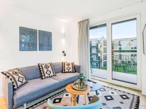 a living room with a couch and a large window at Apartment Fiddy by Interhome in Lembruch