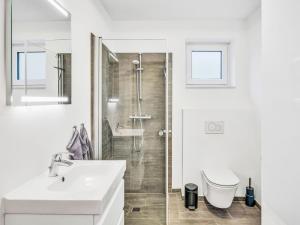 a white bathroom with a shower and a sink at Apartment Seewind by Interhome in Lembruch