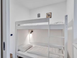 a white bunk room with white bunk beds at Apartment Seetraum by Interhome in Lembruch