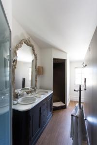 ein Badezimmer mit zwei Waschbecken und einem großen Spiegel in der Unterkunft Le Relais de Franc Mayne Saint Emilion in Saint-Émilion