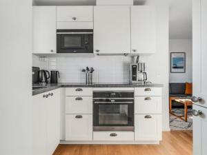 a kitchen with white cabinets and a stove top oven at Apartment Ama - 350m from the sea by Interhome in Østerby Havn