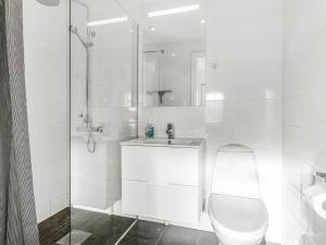 a white bathroom with a toilet and a sink at Apartment Ama - 350m from the sea by Interhome in Østerby Havn +4 photos