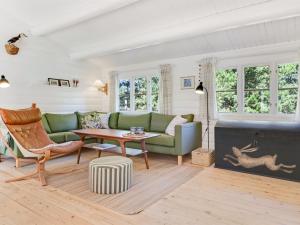 a living room with a green couch and a table at Holiday Home Reinhardt - 800m from the sea by Interhome in Mølby